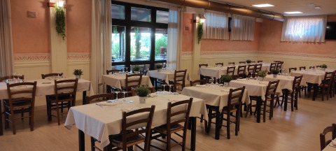 Comedor con mesas y sillas preparadas en Centro Vacanze San Marino, un parque vacacional en San Marino.