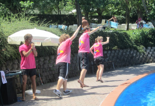 Animatori in magliette rosa intrattengono vicino alla piscina al Centro Vacanze San Marino, San Marino.