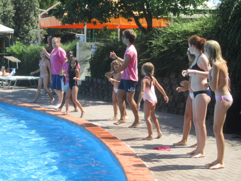 Kinderen en volwassenen spelen aan het zwembad van Centro Vacanze San Marino vakantiepark in San Marino.
