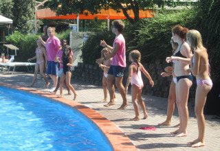 Kinderen en volwassenen spelen aan het zwembad van Centro Vacanze San Marino vakantiepark in San Marino.