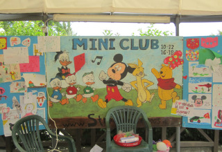 Kleurrijk Mini Club-bord met Disneyfiguurtjes en kindertekeningen in het vakantiepark Centro Vacanze San Marino.