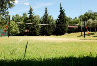 Terrain de volley en plein air au Centro Vacanze San Marino, entouré d’arbres et d’herbe verte.