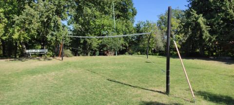 Volleybalplein in open lucht bij Centro Vacanze San Marino, omringd door gras en groene bomen.