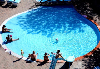Famiglie si rilassano nella piscina all'aperto del Centro Vacanze San Marino, villaggio vacanze a San Marino.