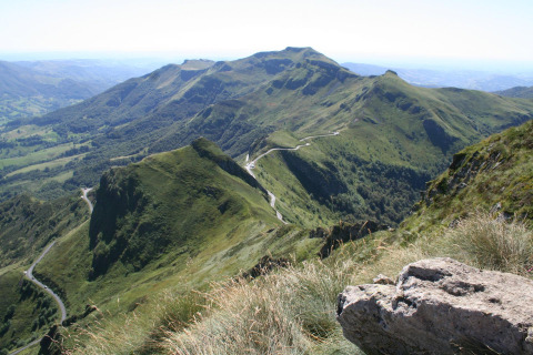 Scenic view of green mountains and winding road near Saint Constant in Auvergne-Rhône-Alpes, France.