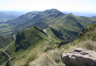 Scenic view of green mountains and winding road near Saint Constant in Auvergne-Rhône-Alpes, France.