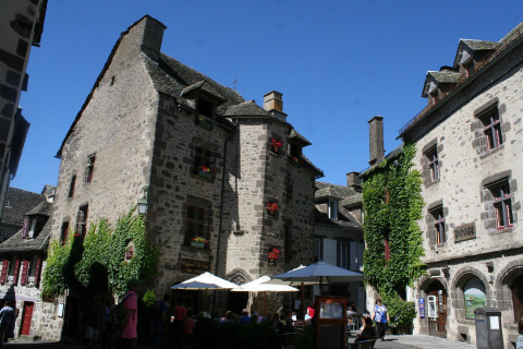 Edifici in pietra e caffè al campeggio Moulin de Chaules, parco vacanze in Alvernia-Rodano-Alpi, Francia, in una giornata di sole.