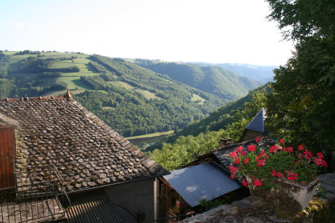 Vista su colline verdi e tetti rustici dal campeggio Moulin de Chaules in Alvernia-Rodano-Alpi, Francia.