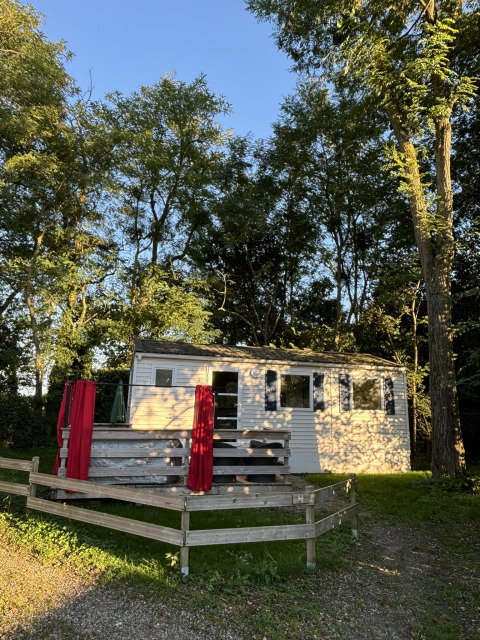 Bungalow Les Croisettes met jacuzzi en terras tussen bomen, badend in de namiddagzon.