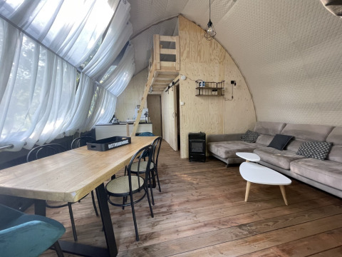 Binnenaanzicht van safari lodge ‘Big Oak XXL’ op Camping Moulin de Chaules, met modern houten interieur.