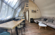 Interior view of Lodge ‘Big Oak XXL’ safari tent at Campsite Moulin de Chaules, featuring modern wooden decor.