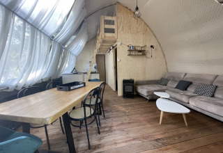 Vista interna della tenda safari Lodge 'Big Oak XXL' al campeggio Moulin de Chaules, con arredi moderni in legno.