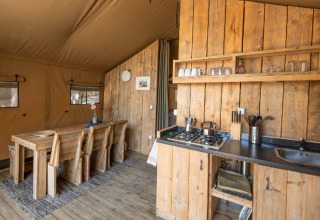 Intérieur d’une tente glamping Centro Vacanze San Marino - Safaritenten San Marino, bois et cuisine équipée.