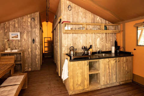 Vue intérieure d'une tente safari de luxe au Centro Vacanze San Marino avec décoration en bois.