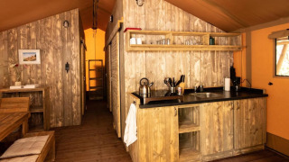 Vue intérieure d'une tente safari de luxe au Centro Vacanze San Marino avec décoration en bois.