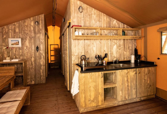 Vue intérieure d'une tente safari de luxe au Centro Vacanze San Marino avec décoration en bois.