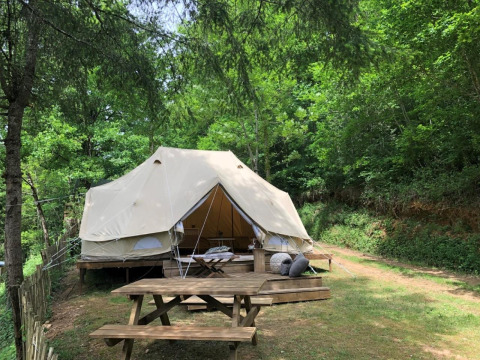Tenda Emperor Bell Tent al campeggio Moulin de Chaules in Francia, immersa nel verde con tavolo da picnic.