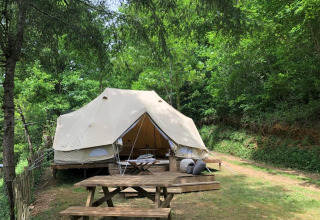 Emperor Bell Tent at Moulin de Chaules campsite in France, nestled in greenery with a wooden picnic table.