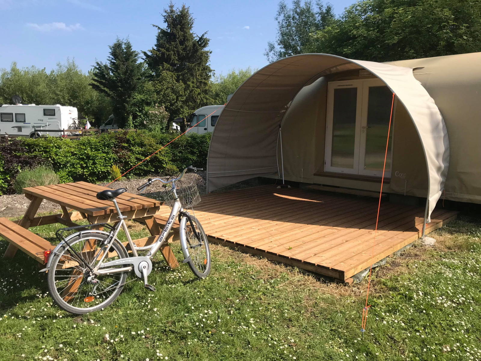 Cocosweet safaritent met fiets en picknicktafel bij Flower Camping de la Trye in Frankrijk.