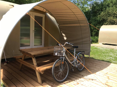 Cocosweet safaritent bij Flower Camping de la Trye in Frankrijk met fiets en picknicktafel op het terras.