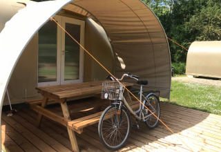 Cocosweet safaritent bij Flower Camping de la Trye in Frankrijk met fiets en picknicktafel op het terras.