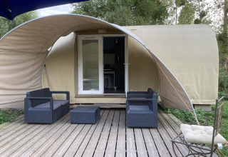 Cocosweet safaritent bij Flower Camping de la Trye in Frankrijk met houten terras en buitenzitje.