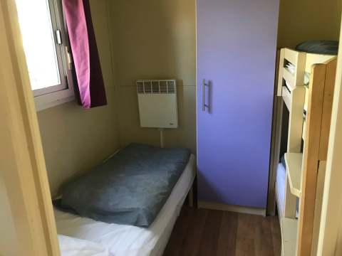 Small bedroom in Green Chalet at Flower Camping de la Trye with single bed, bunk beds and wardrobe.
