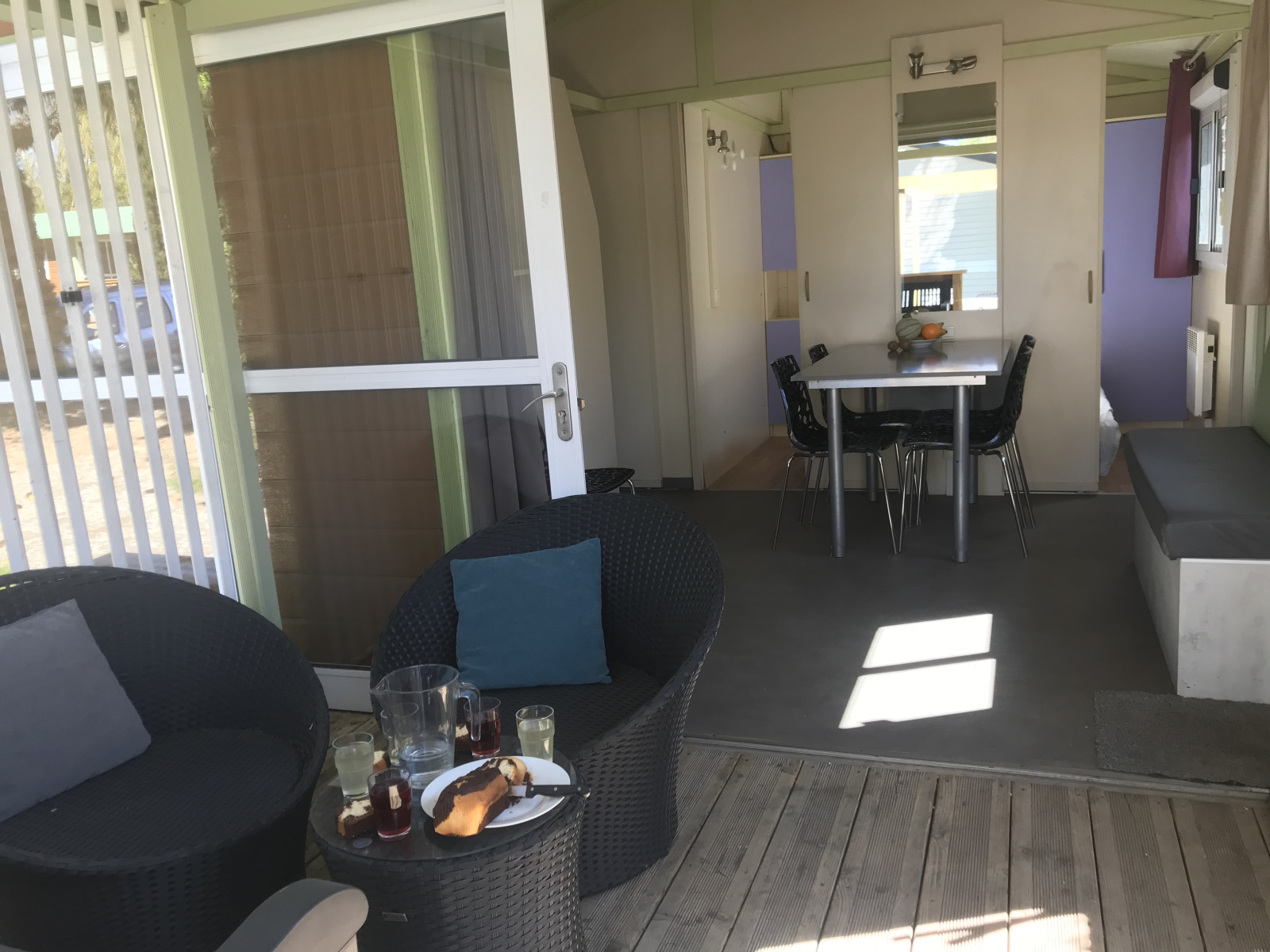 Chalet du Bélier bij Flower Camping de la Trye met terras, stoelen en eetgedeelte binnen in Frankrijk.