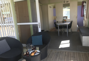 Udendørs og indendørs opholdsområde i Chalet du Bélier med spisebord, stole og terrasse i Frankrig.