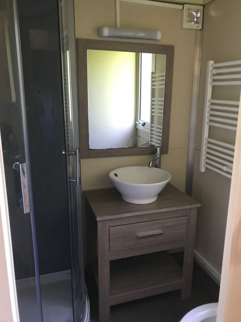 Moderne badkamer in Chalet du Bélier + Jacuzzi op Flower Camping de la Trye, Frankrijk, met wasbak en douche.