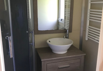 Moderne badeværelse i Chalet du Bélier + Jacuzzi på Flower Camping de la Trye, med håndvask og brusekabine.