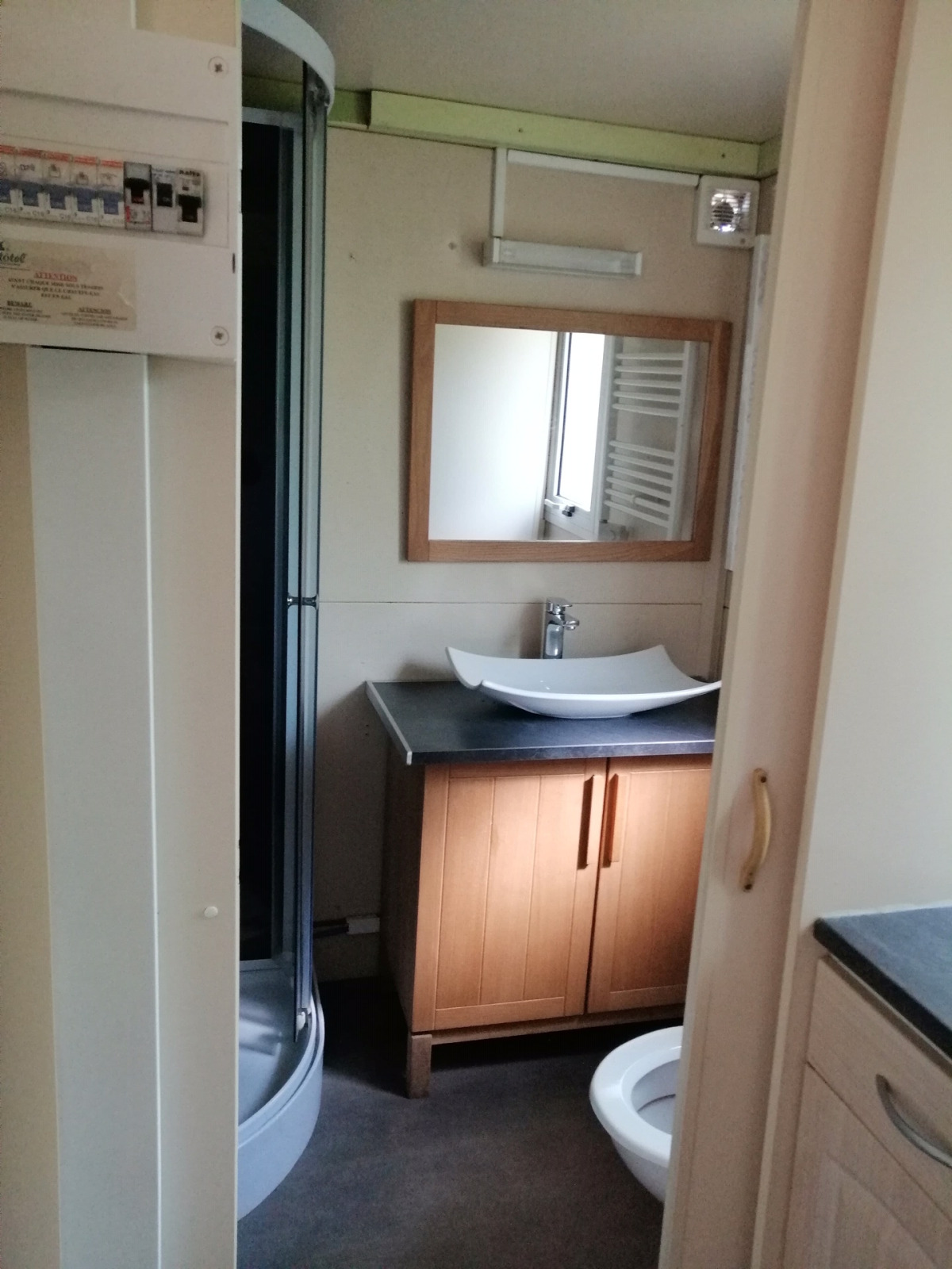 Badkamer in Chalet du Bélier bij Flower Camping de la Trye, Frankrijk, met wastafel, spiegel en douche.