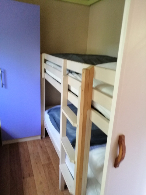 Slaapkamer met stapelbed en paarse kast in Chalet du Bélier bij Flower Camping de la Trye, Frankrijk.
