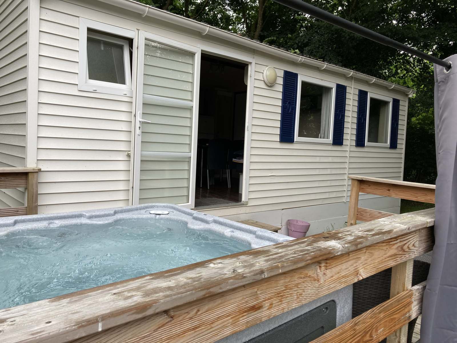 Bubbelbad buiten op houten terras bij Bungalow Les Croisettes op Flower Camping de la Trye in Frankrijk.