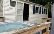 Bubbelbad buiten op houten terras bij Bungalow Les Croisettes op Flower Camping de la Trye in Frankrijk.