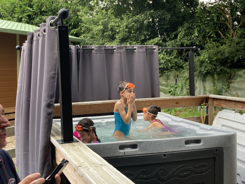 Kinderen spelen in een buitenjacuzzi bij Bungalow Les Croisettes, Flower Camping de la Trye, Frankrijk.
