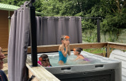 Kinderen spelen in een buitenjacuzzi bij Bungalow Les Croisettes, Flower Camping de la Trye, Frankrijk.