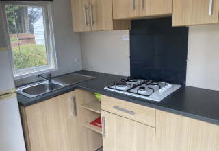 Modern kitchenette in Mobile home Grand Confort at Flower Camping de la Trye with a gas hob and sink.