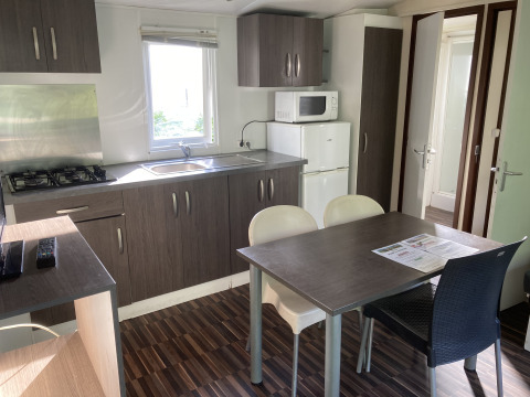 Cucina moderna e zona pranzo in una Mobile home «Grand Confort» al Flower Camping de la Trye in Francia.
