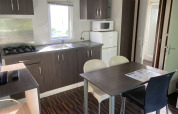 Modern kitchen and dining area inside a Mobile home «Grand Confort» at Flower Camping de la Trye, France.