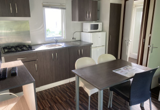 Modern kitchen and dining area inside a Mobile home «Grand Confort» at Flower Camping de la Trye, France.