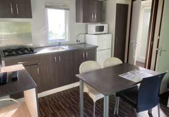 Moderne køkken og spisestue i en Mobile home «Grand Confort» på Flower Camping de la Trye i Frankrig.