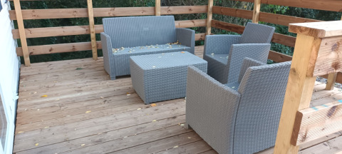 Terrasse mit grauen Korbmöbeln und Holzgeländer im Mobile Home „Grand Confort“ auf Flower Camping de la Trye.