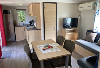 Binnenzicht van Bungalow du Parc + jacuzzi aan Flower Camping de la Trye, Frankrijk, met keuken en zithoek.