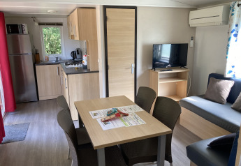 Interior view of Bungalow du Parc + jacuzzi at Flower Camping de la Trye, France, showing kitchen and lounge.