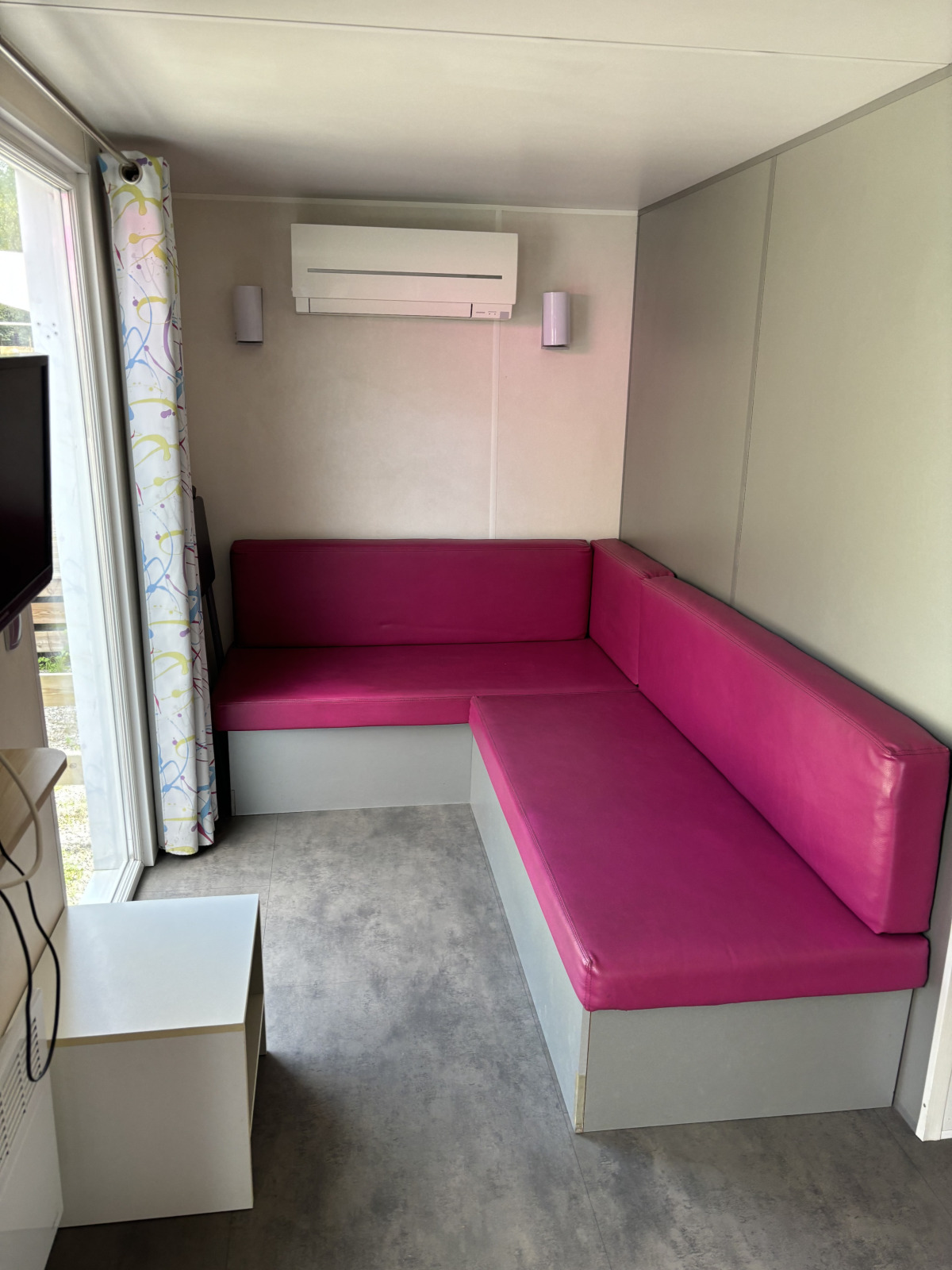 Kleine zithoek met roze banken in Bungalow La Folle Entreprise bij Flower Camping de la Trye, Frankrijk.