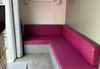 Petit salon avec canapés roses dans le Bungalow La Folle Entreprise, Flower Camping de la Trye, France.