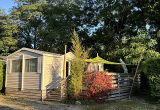 Bungalow du Gorguet met jacuzzi bij Flower Camping de la Trye in Frankrijk, omgeven door bomen en zon.