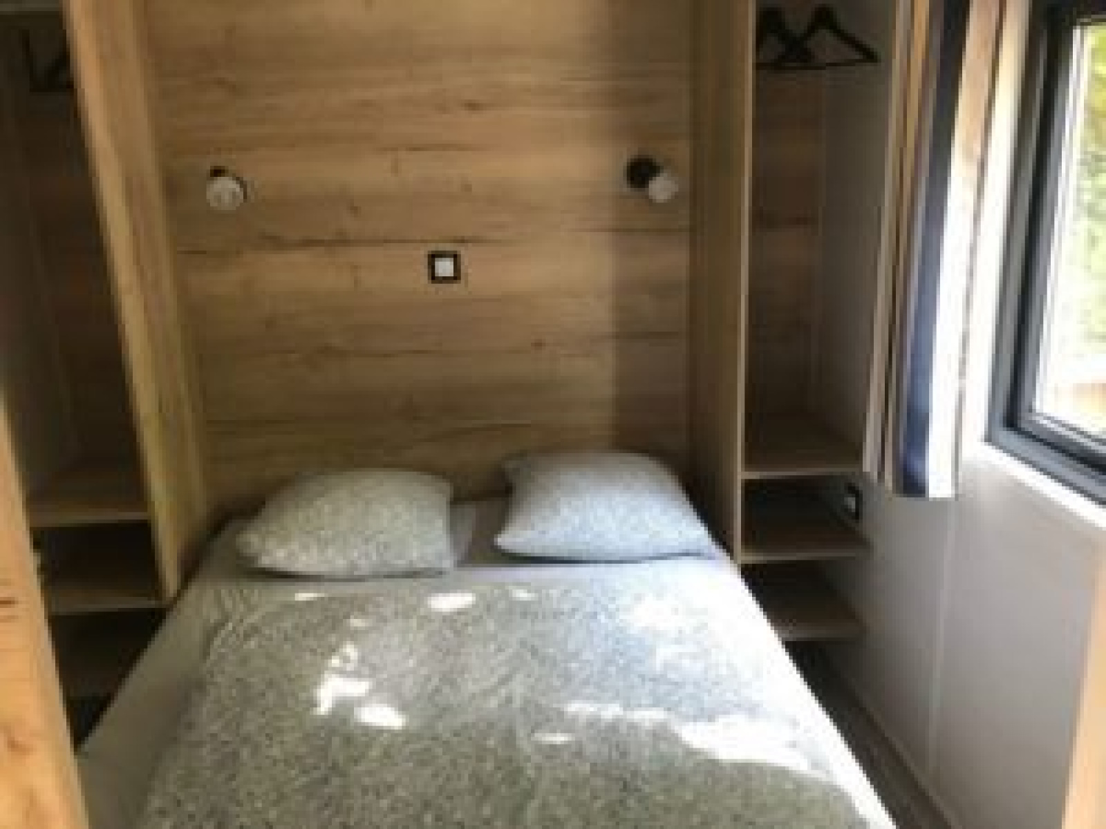 Slaapkamer in Tiny House met tweepersoonsbed en houten wanden, Flower Camping de la Trye, Frankrijk.