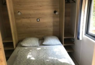Slaapkamer in Tiny House met tweepersoonsbed en houten wanden, Flower Camping de la Trye, Frankrijk.
